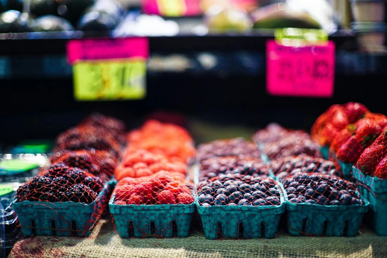 a close up of baskets of berries on a table, by Meredith Dillman, unsplash, colored fruit stand, 2 5 6 x 2 5 6 pixels, seattle, exterior shot