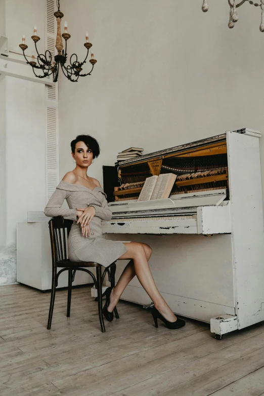 a woman sitting at a piano in a room, full body photoshoot, style of anton fadeev, in a white room, sitting on a mocha-colored table