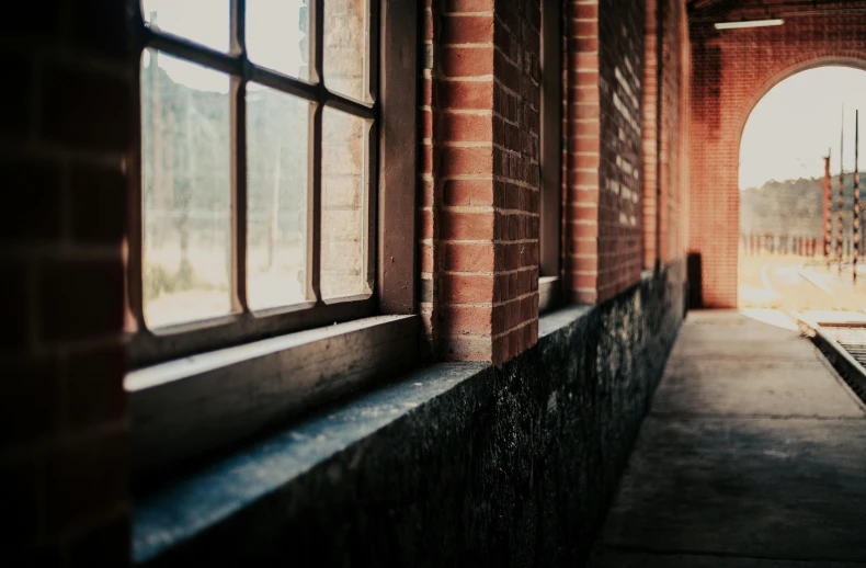 the sun shines through the windows of a brick building, pexels contest winner, light and space, rusted silent hill, sliding glass windows, looking sideway, background image