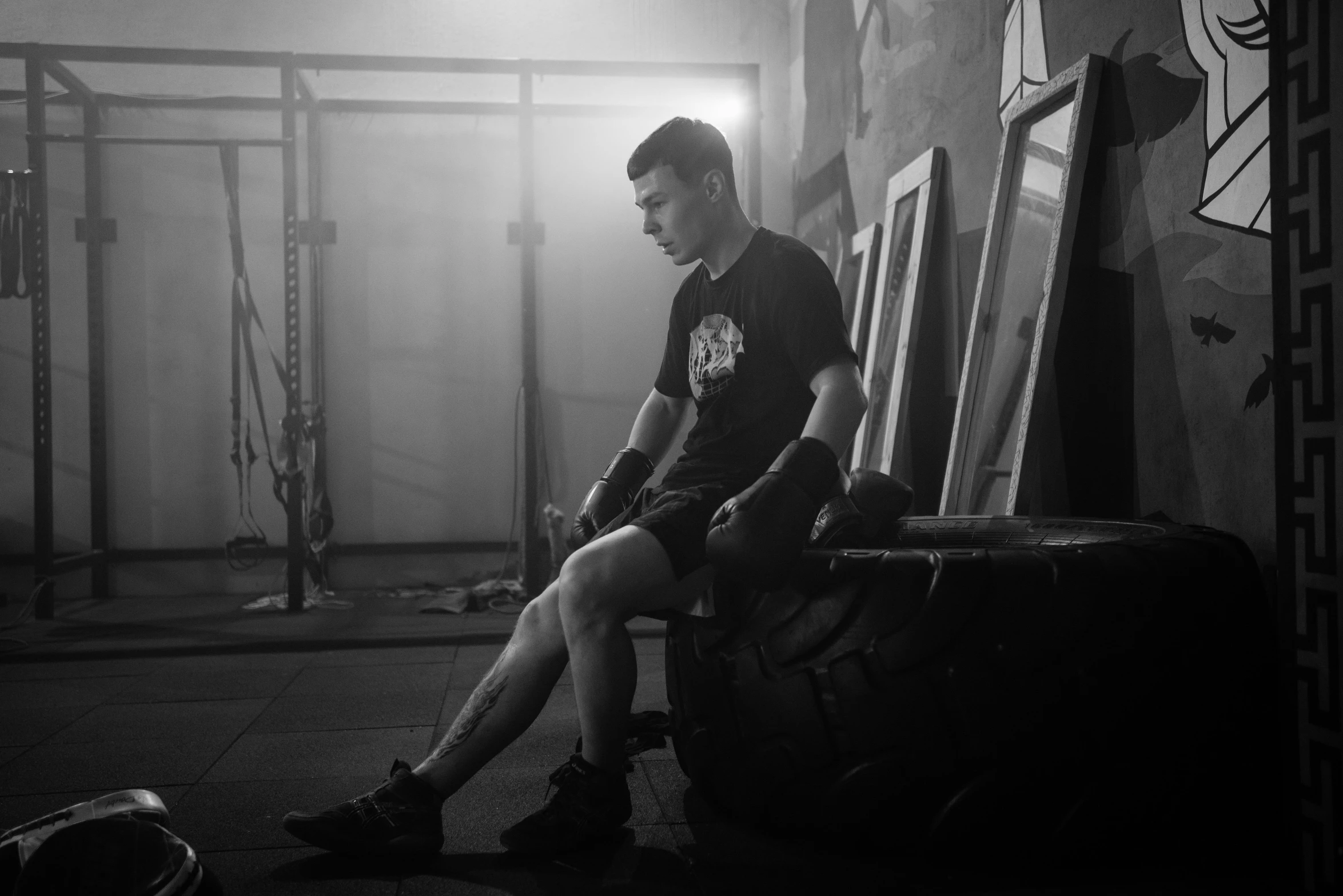 a man sitting on a bench in a gym, a portrait, by Adam Marczyński, pexels contest winner, preparing to fight, wearing a tee shirt and combats, vantablack gi, ukrainian