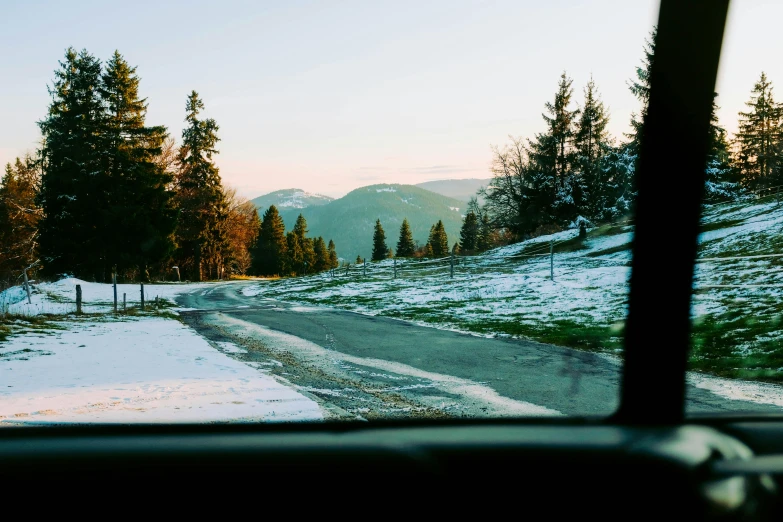 a view of a road through the windshield of a car, by Tobias Stimmer, pexels contest winner, carpathian mountains, holiday season, back facing the camera, looking left