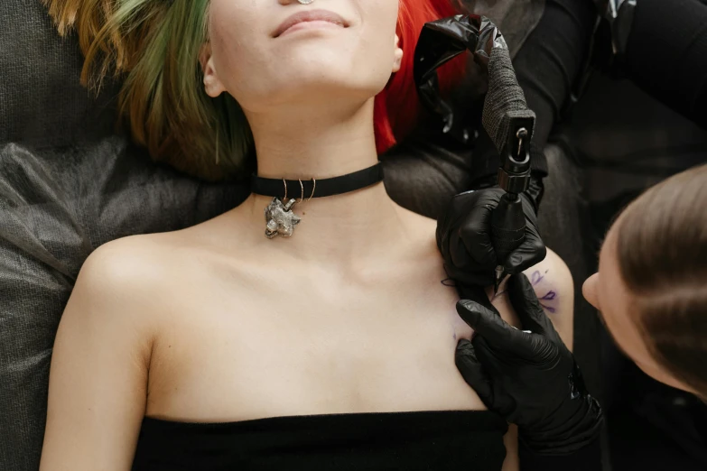 a woman with green hair is getting her hair done, a tattoo, inspired by Taro Yamamoto, trending on pexels, aestheticism, collar and leash, arca album cover, resting on chest, black