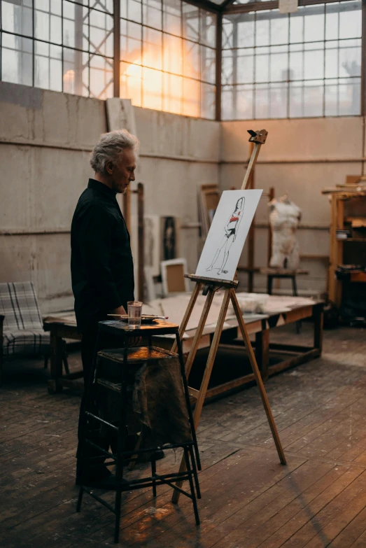 a man that is standing in front of a easel, inspired by Art Brenner, pexels contest winner, portrait of hide the pain harold, inspect in inventory image, elegant drawing, style steve mccurry