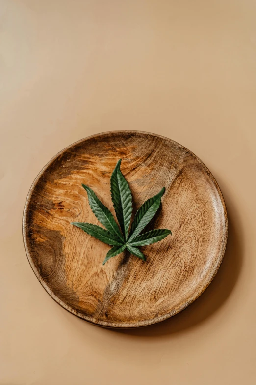 a wooden plate with a marijuana leaf on it, a still life, trending on pexels, renaissance, made of glazed, high grain, product image, high detal