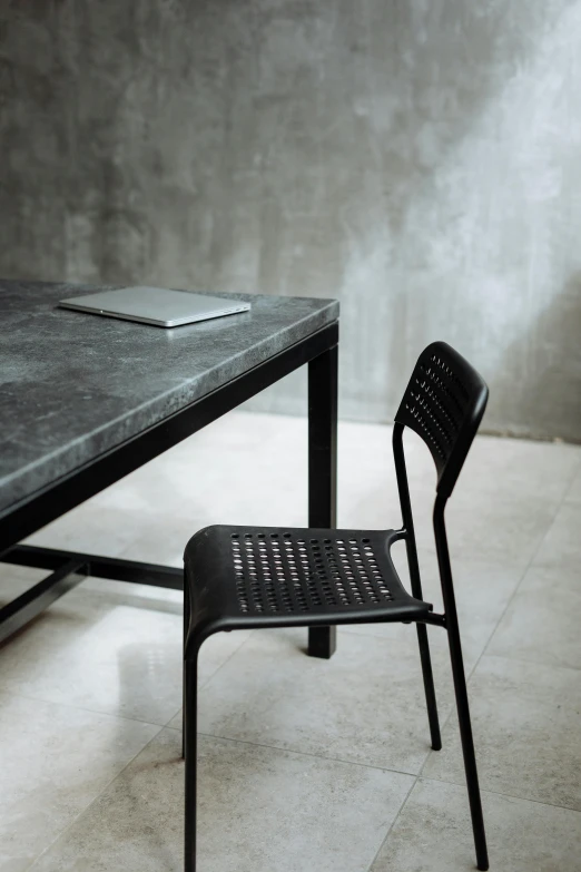 a table with a chair and a laptop on it, inspired by Constantin Hansen, unsplash, renaissance, black marble, perforated metal, celebration, looking left