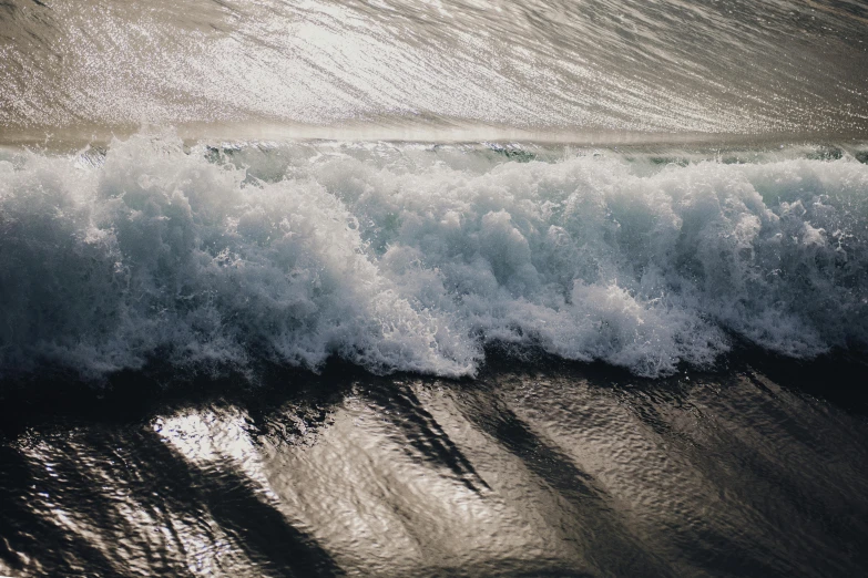 a man riding a wave on top of a surfboard, unsplash, photorealism, sea foam, thumbnail, shimmering, abstract photography