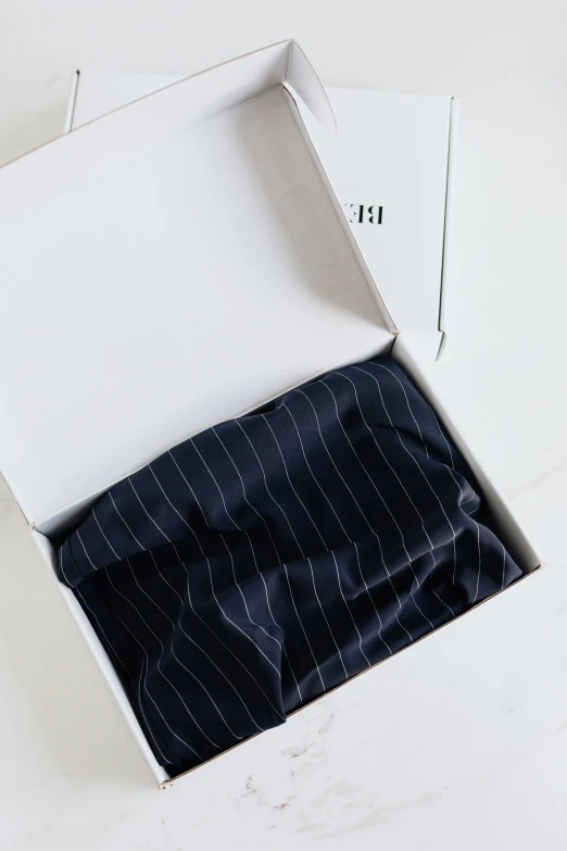 a box that has a tie in it, by Nina Hamnett, unsplash, wearing a pinstripe suit, ouchh and and innate studio, yukata clothing, inside its box