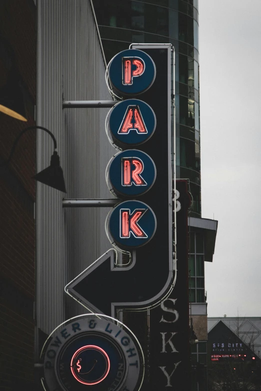 a neon sign on the side of a building, parks, 2019 trending photo, vintage photo, multiple stories