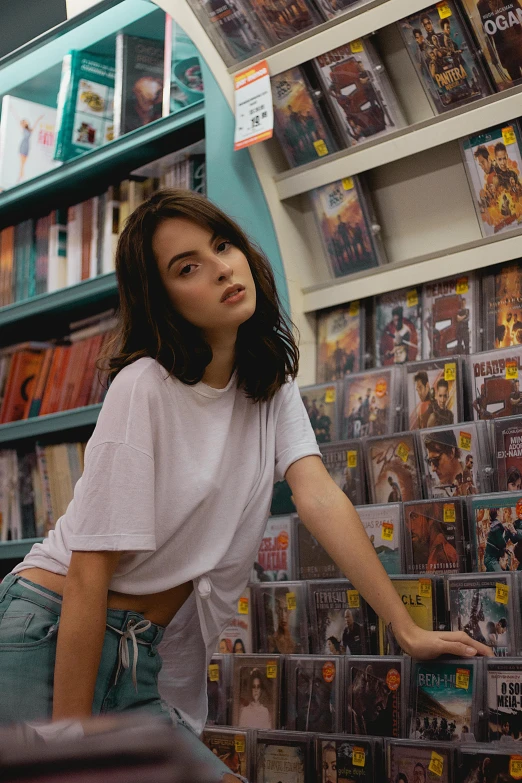 a woman leaning on a shelf in a store, an album cover, inspired by Elsa Bleda, trending on pexels, hyperrealism, isabela moner, croptop, handsome girl, librarian