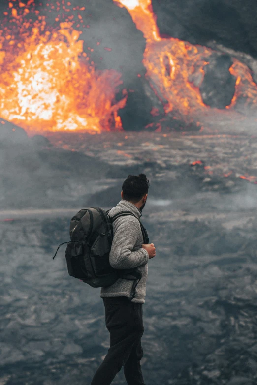 a man with a backpack standing in front of a lava flow, trending on unsplash, barrel fires and tents, college, burned, action scene