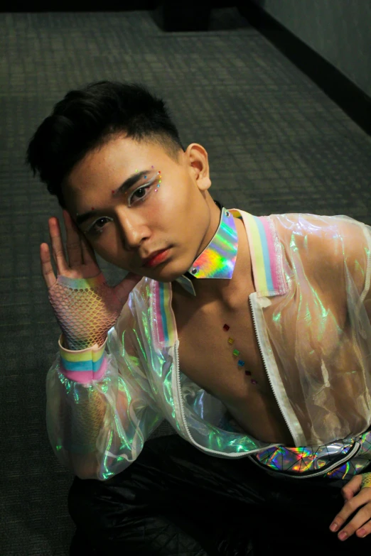 a man in a shiny shirt posing for a picture, an album cover, inspired by Yanjun Cheng, trending on pexels, holography, lgbt, spiked collars, asian, androgynous