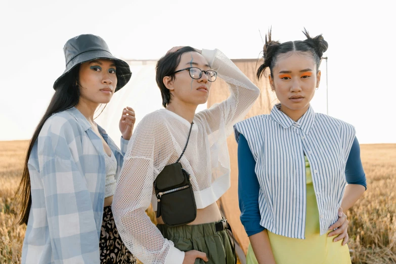 three women standing next to each other in a field, inspired by Ren Hang, trending on pexels, gutai group, brutalist fashion show, a young asian woman, on rooftop, pigtails hairstyle