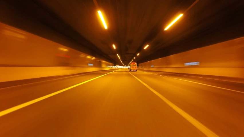 a car driving through a tunnel at night, unsplash, fan favorite, cardboard, orange lights, accurate roads