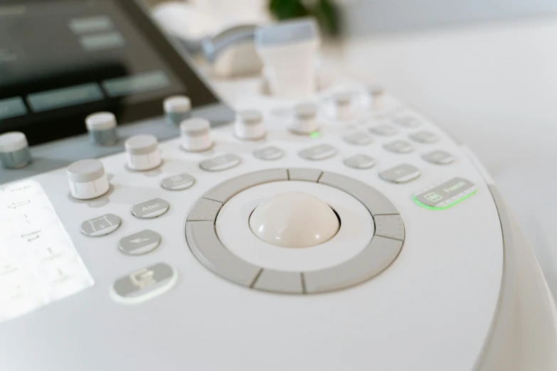 a close up of a remote control on a table, a photocopy, by Julian Allen, unsplash, private press, medical equipment, white and silver, exquisit facial detail, ultradetailed