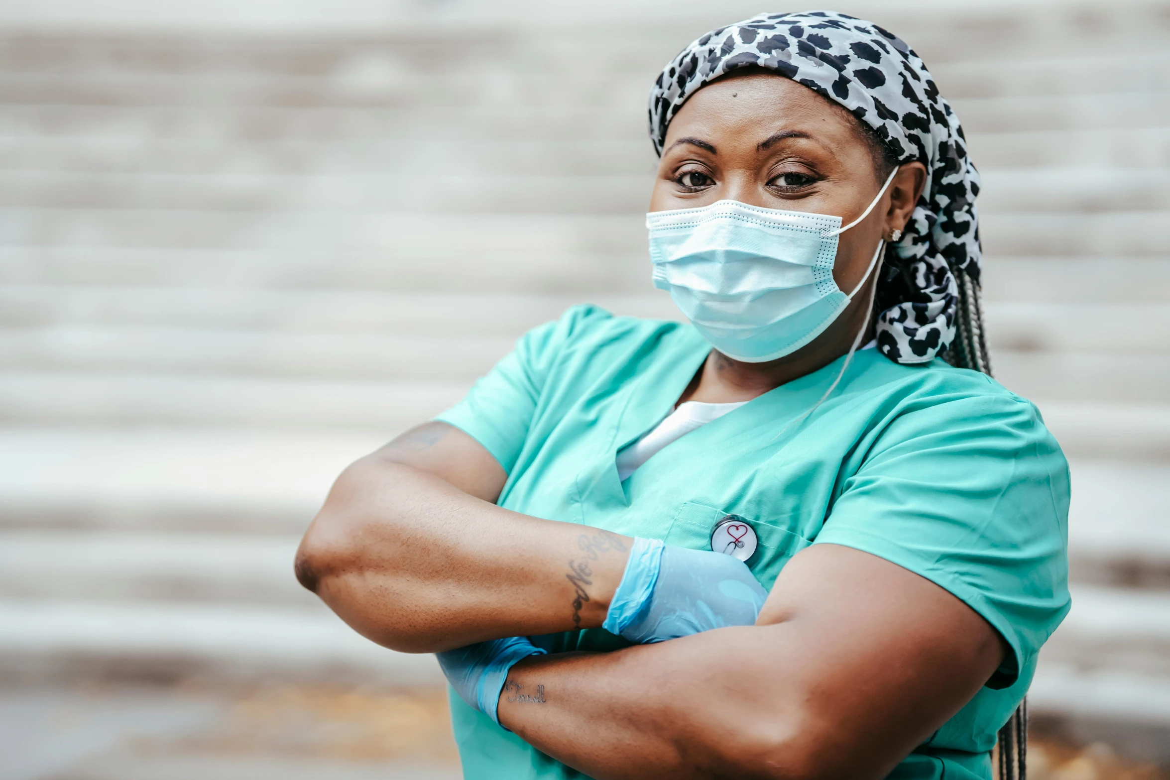 a woman wearing a surgical mask and gloves, a portrait, by Meredith Dillman, trending on pexels, arms crossed, african woman, nurse costume, a person standing in front of a