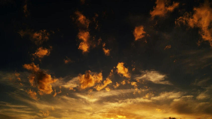 a large body of water under a cloudy sky, an album cover, by James Morris, unsplash, romanticism, dappled golden sunset, black clouds, (night), tall fluffy clouds