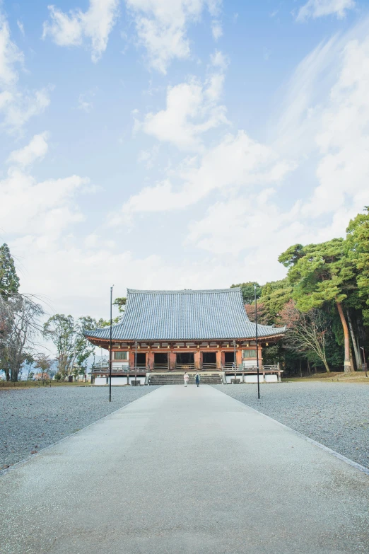 a walkway in front of a building on a sunny day, inspired by Itō Jakuchū, unsplash, sōsaku hanga, big trees, square, holy place, blue sky