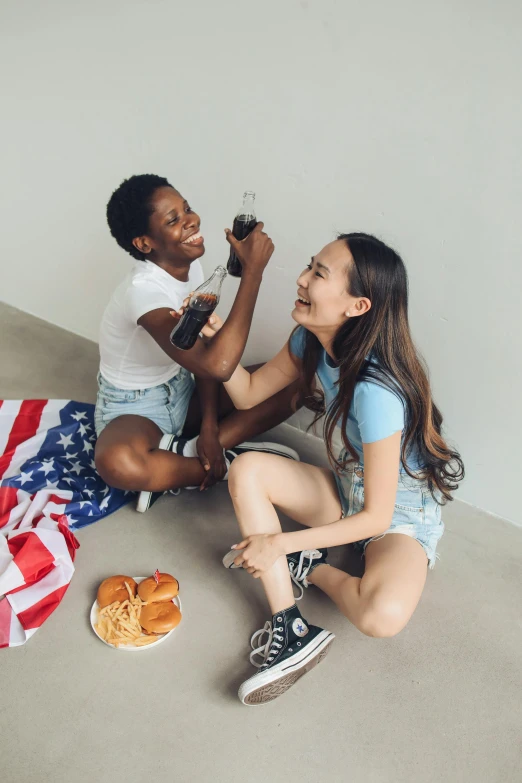 a couple of people that are sitting on the ground, pexels contest winner, american romanticism, battle toast, us flag, asian female, full product shot