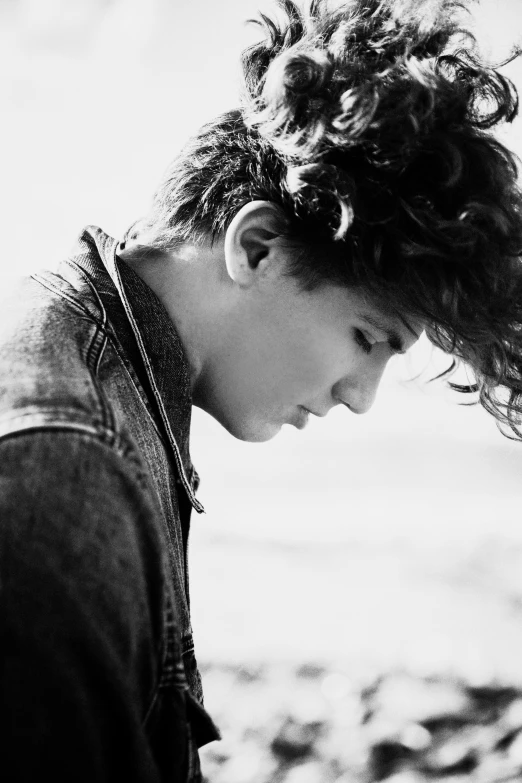 a black and white photo of a boy on the beach, inspired by Kristian Kreković, tumblr, with curls, declan mckenna, profile image, young adult male