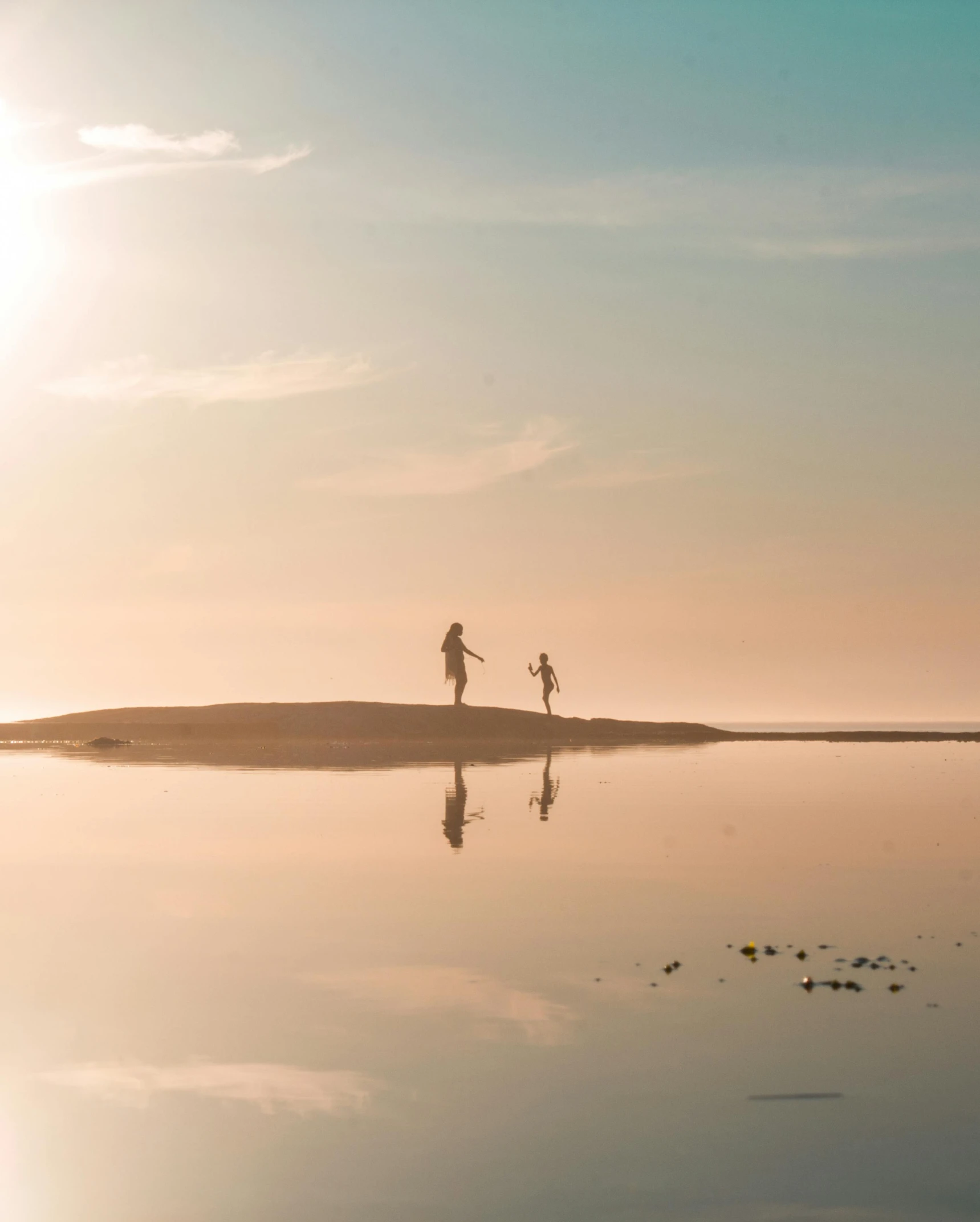 a couple of people standing on top of a sandy beach, by Jan Tengnagel, pexels contest winner, minimalism, kids, standing in a pond, running freely, beautiful late afternoon