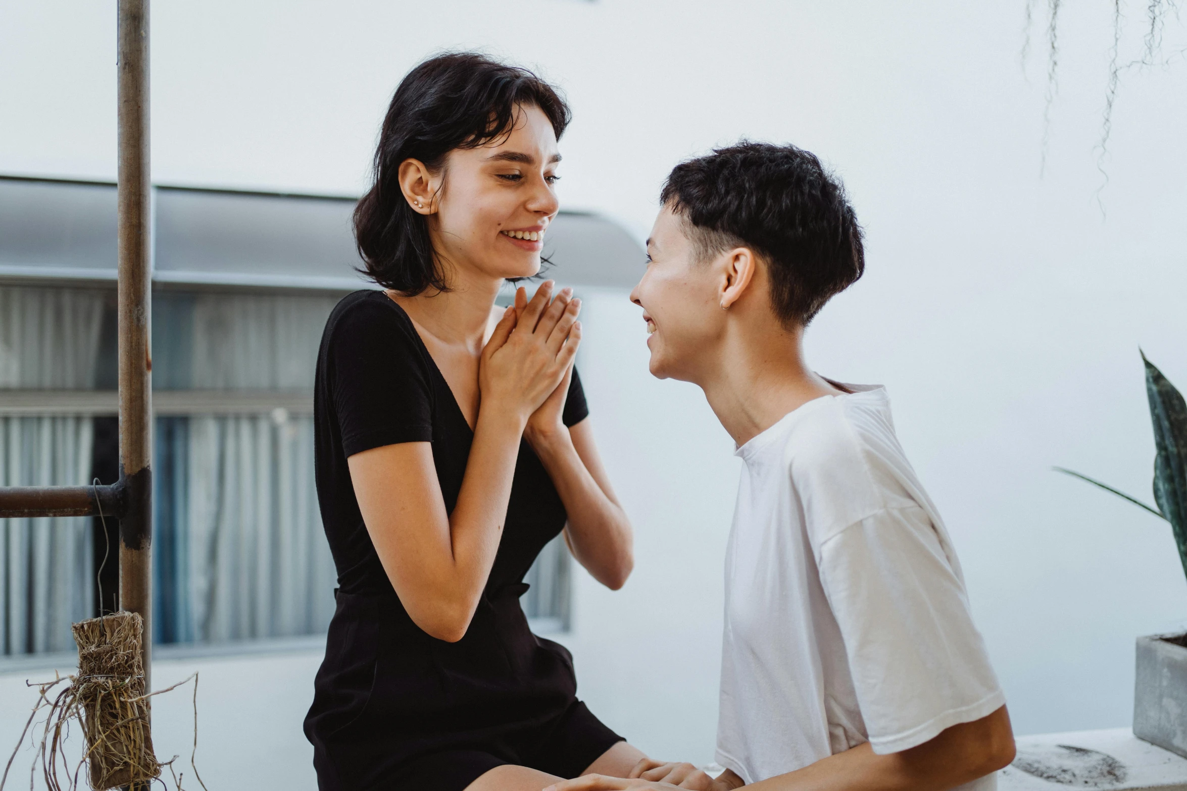 a man and a woman sitting next to each other, trending on pexels, antipodeans, lesbian embrace, earing a shirt laughing, profile image, asian female