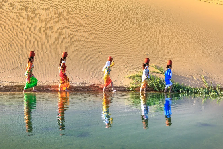 a group of women carrying water on their heads, inspired by Steve McCurry, pexels contest winner, in a desert oasis lake, avatar image, colorful photo, girl walking between dunes