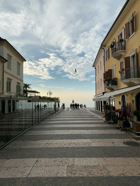 a group of people walking down a street next to tall buildings, inspired by Gaetano Sabatini, unsplash contest winner, renaissance, beautiful italian beach scene, 2 5 6 x 2 5 6 pixels, taken on iphone 1 3 pro, seaview