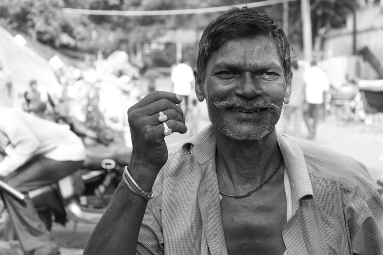 a black and white photo of a man with a mustache, by Kailash Chandra Meher, pexels contest winner, samikshavad, flaunting his wealth, friendly guy and small creature, cigarette in hand, smiling for the camera