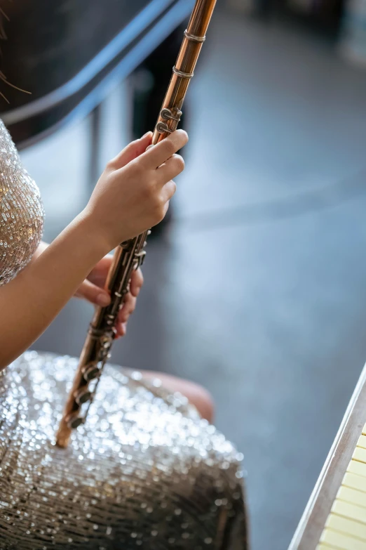 a woman in a silver dress playing a flute, trending on pexels, arabesque, high angle close up shot, slide show, sequins, sleek spines