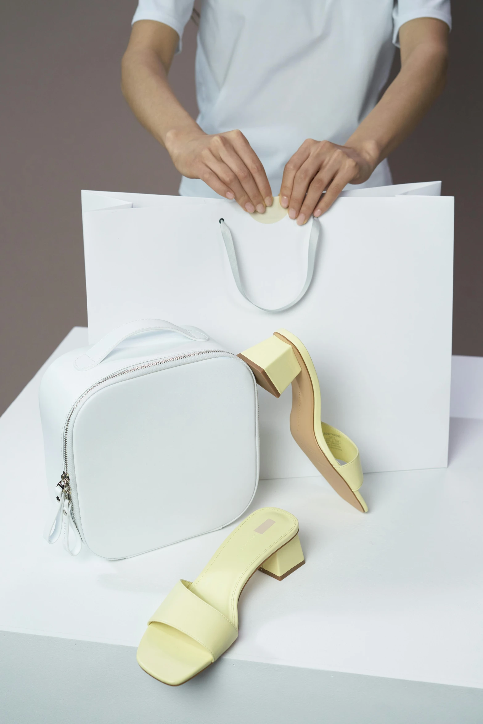 a woman holding a white bag next to a pair of yellow shoes, soft shapes, collection product, pastel', stores