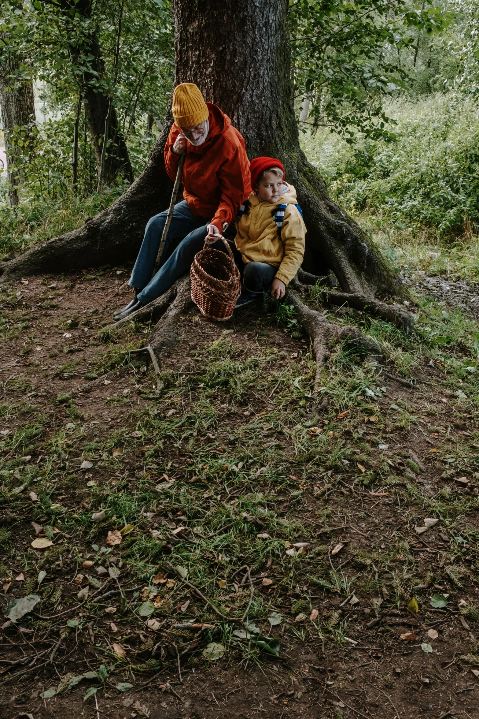 two people sitting under a tree in the woods, pexels contest winner, land art, roots and hay coat, red riding hood, high angle, the gruffalo