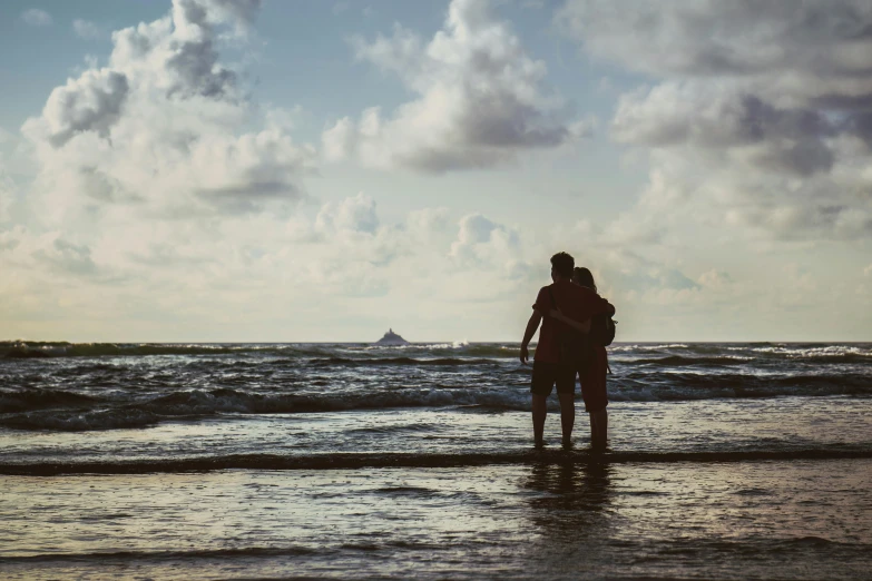 a couple of people that are standing in the water, a picture, unsplash contest winner, romanticism, ocean in distance, profile image, thumbnail, beach setting medium shot