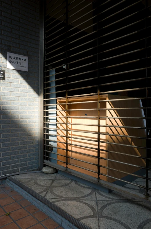 a red fire hydrant sitting in front of a building, an album cover, by Yasushi Sugiyama, shin hanga, black vertical slatted timber, light entering through a blind, private academy entrance, sun glare