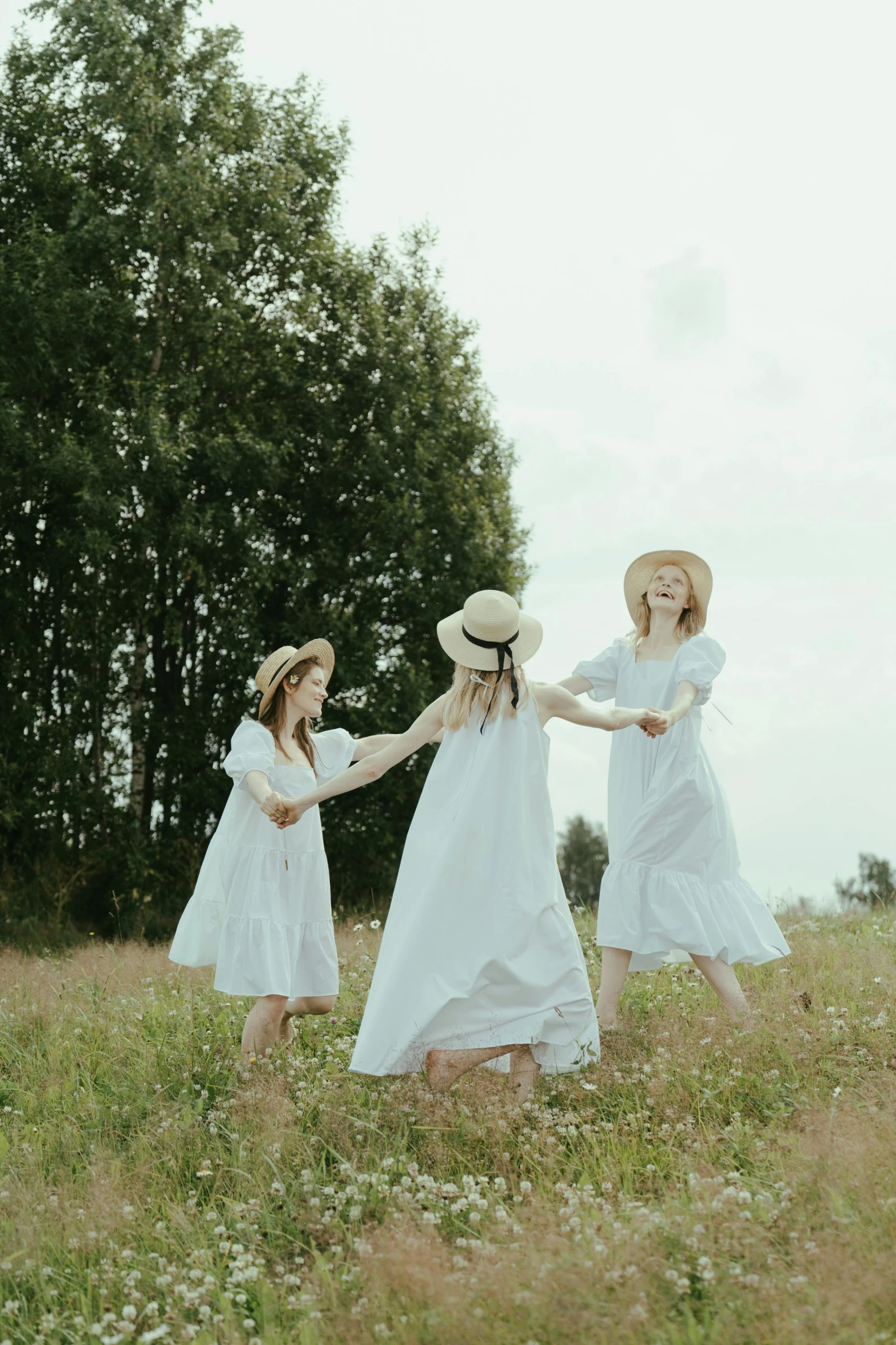 three women in white dresses holding hands in a field, inspired by Elsa Beskow, pexels contest winner, white hat, playing, low quality photo, russian clothes