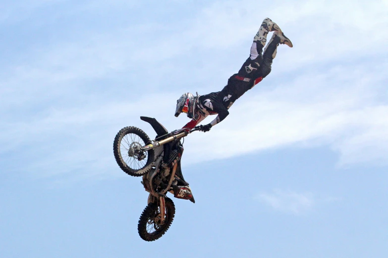 a man flying through the air while riding a motorcycle, doing a backflip, profile image, danny fox, show from below