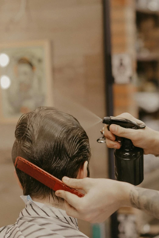 a man getting his hair cut at a barber shop, trending on pexels, medium shot taken from behind, thumbnail, hairspray, vintage inspired