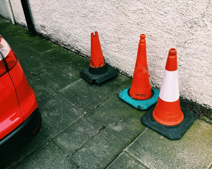 a couple of traffic cones sitting next to a red car, unsplash, hyperrealism, in scotland, 4 cannabis pots, construction, 1980s photo