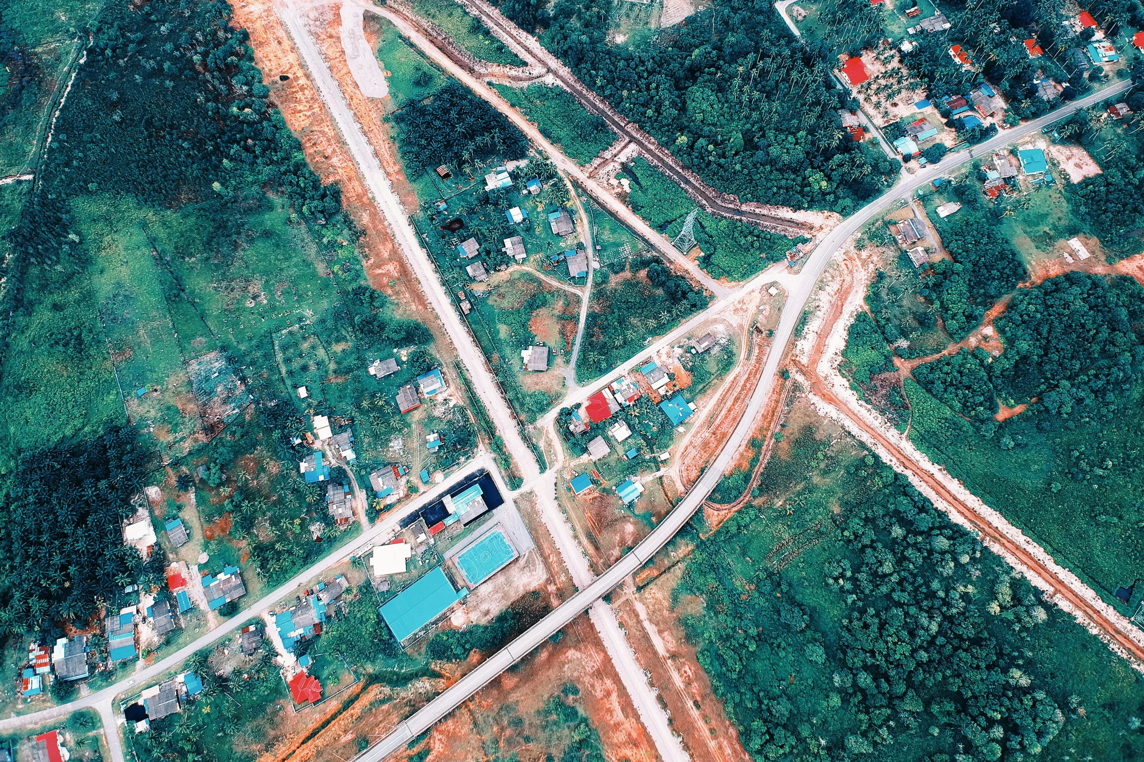 an aerial view of a small town surrounded by trees, a colorized photo, hurufiyya, avatar image, analog photo, construction, patiphan sottiwilaiphong