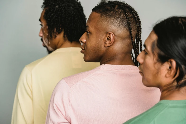 a group of people standing next to each other, by Carey Morris, trending on pexels, renaissance, diverse haircuts, man sitting facing away, brightly coloured, looking from shoulder