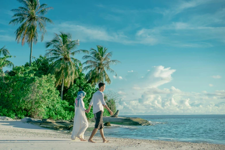 a man and a woman walking on a beach, pexels contest winner, hurufiyya, island background, blue themed, lush surroundings, islamic