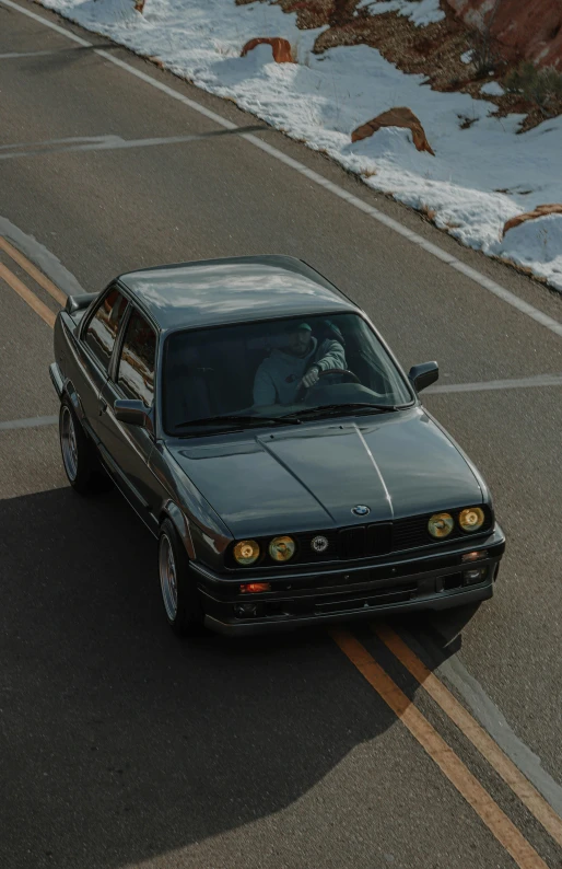 a car that is sitting on the side of a road, bmw e 3 0, on a road