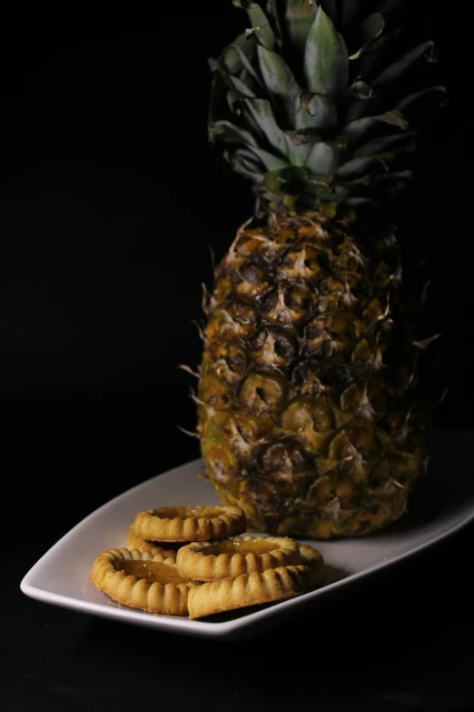 a pineapple sitting on top of a white plate, in front of a black background, cookies, crisps, 王琛