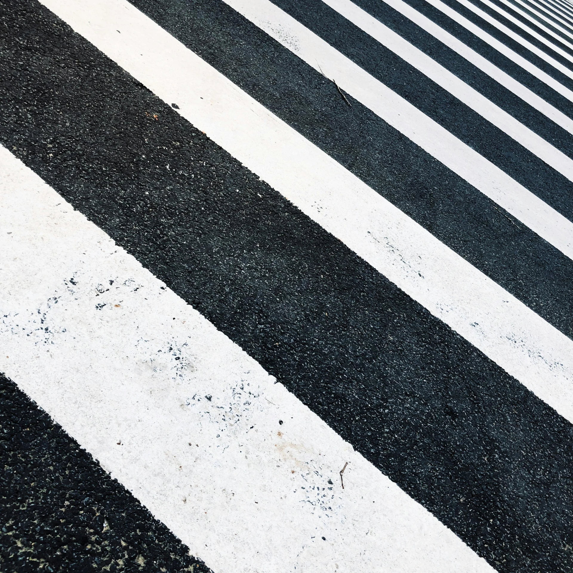 a red fire hydrant sitting on the side of a road, a black and white photo, by Carey Morris, unsplash, hypermodernism, zebra stripes, crossing the line, tokio aoyama, in a row