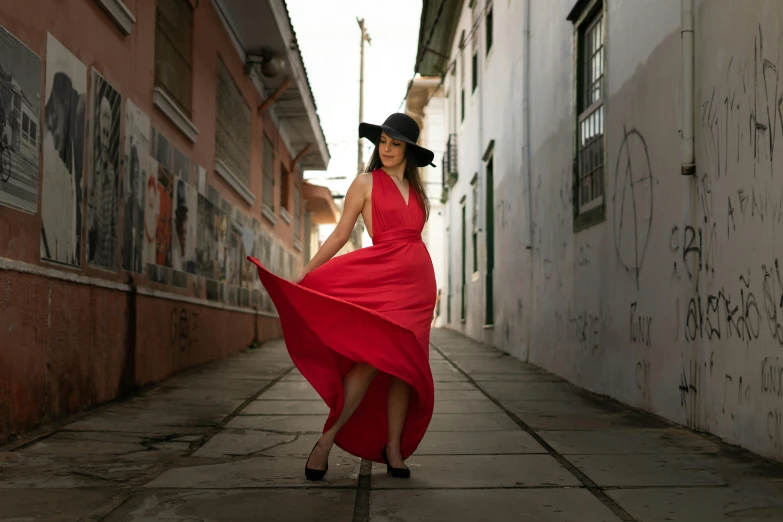 a woman in a red dress and a black hat, a picture, by Gina Pellón, pexels contest winner, on the sidewalk, long dress female, colombian, epic angle and pose
