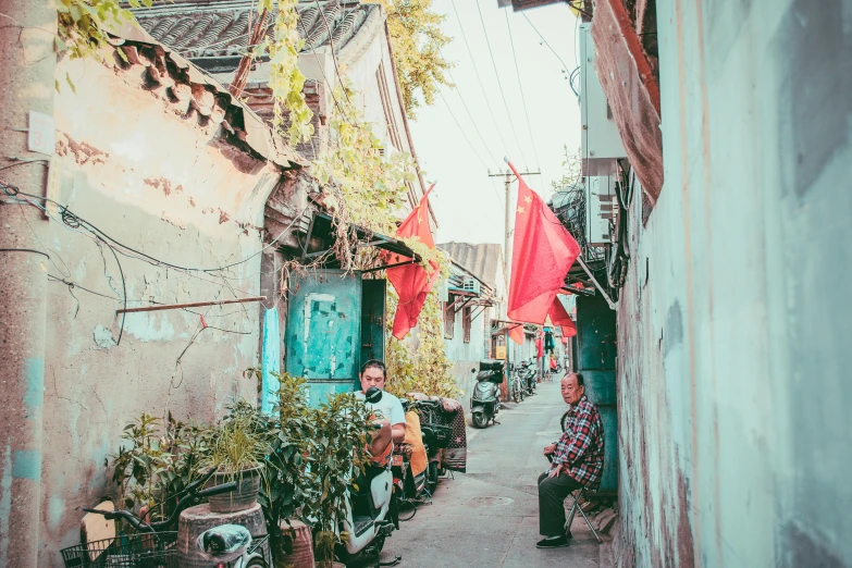 a man sitting on a motor scooter in a narrow alley, pexels contest winner, mingei, red flags holiday, red and cyan, baotou china, people sitting at tables