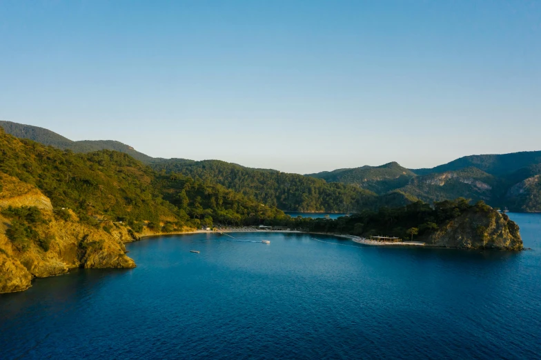 a small island in the middle of a large body of water, picton blue, conde nast traveler photo, shot at golden hour, beach is between the two valleys