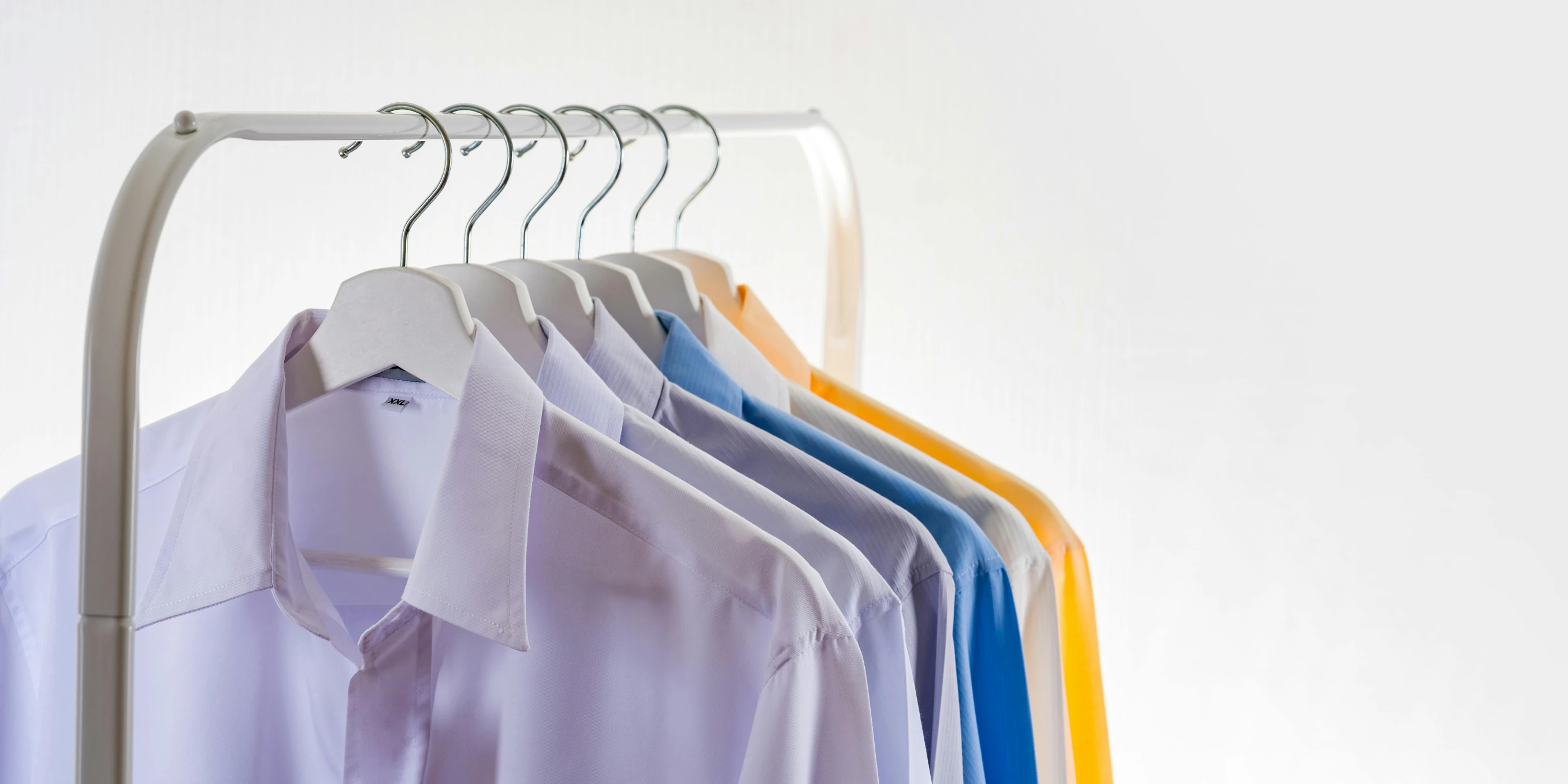 a row of shirts hanging on a clothes rack, by Daniel Gelon, plasticien, sterile colours, uniform plain sky, crisp image