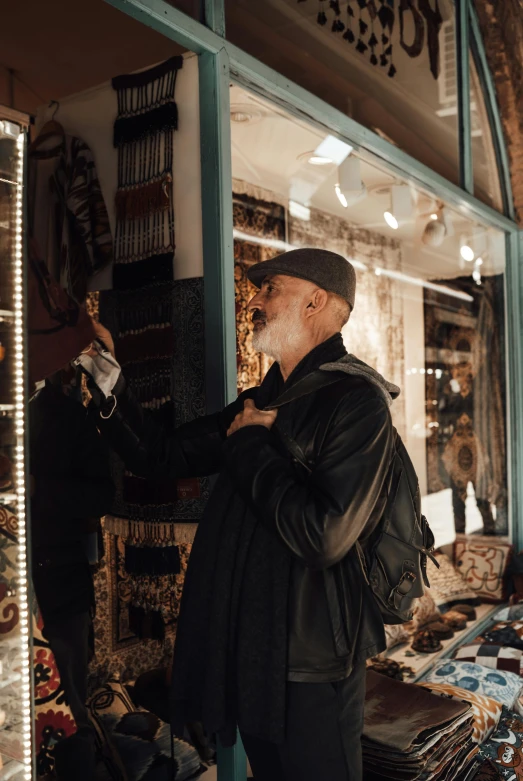 a man that is standing in front of a store, pexels contest winner, art nouveau, arab man light beard, berets, looking in mirror at older self, leather clothing