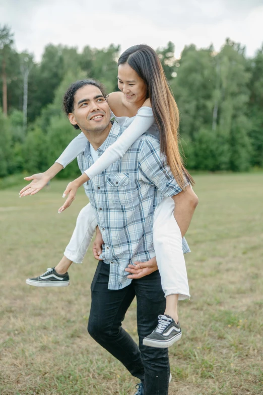 a man carrying a woman on his back in a field, pexels contest winner, attractive pose, casual game, grey, asian male