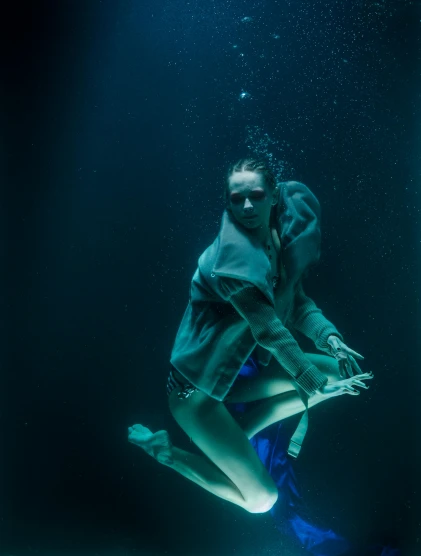 a man diving under the surface of a body of water, a portrait, inspired by Elsa Bleda, unsplash contest winner, process art, wearing a neon blue hoodie, portrait of a woman underwater, ignant, by emmanuel lubezki